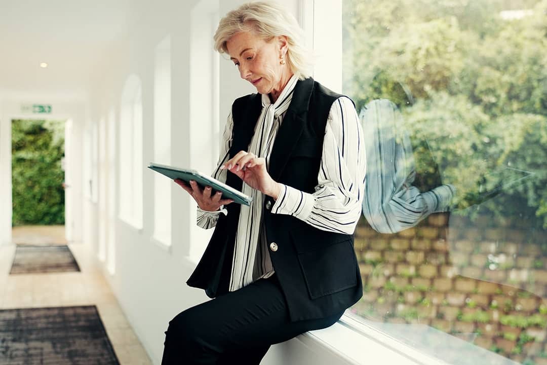 A realtor reviewing property information and viewing schedule from a digital tablet on-site.